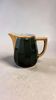 Dark green ceramic decorative jug with golden trim.