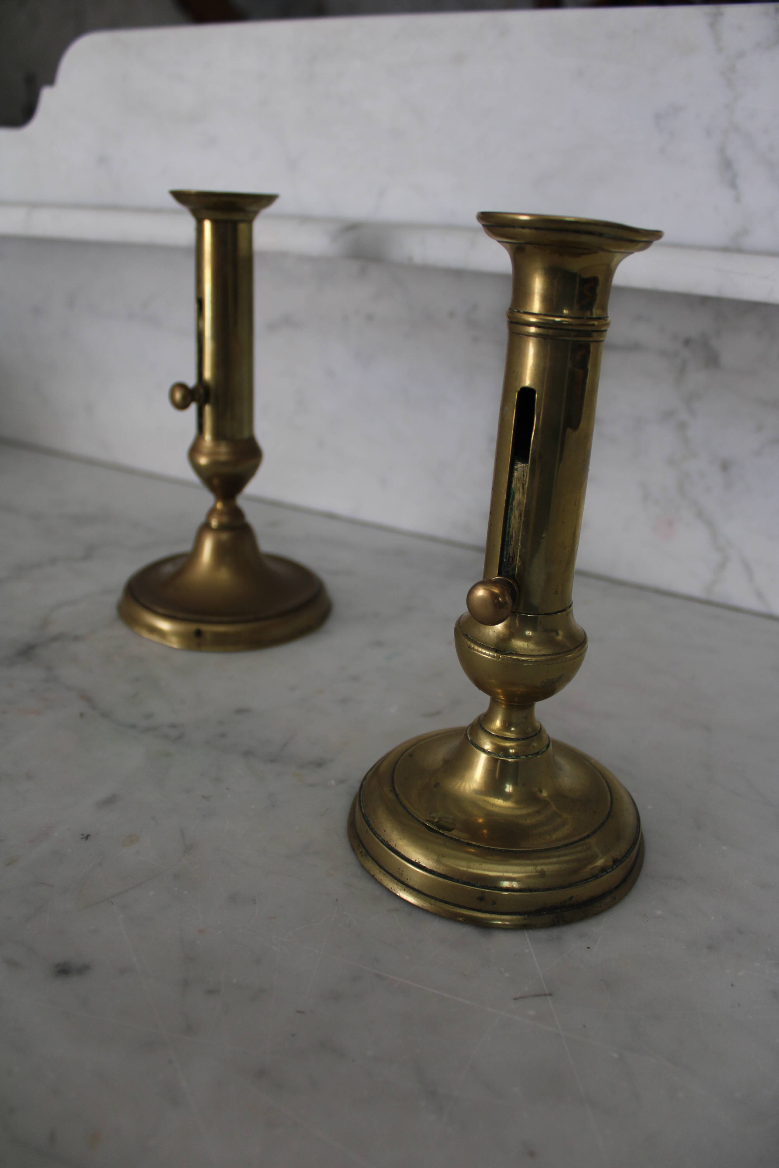 Pair of brass pusher candlesticks