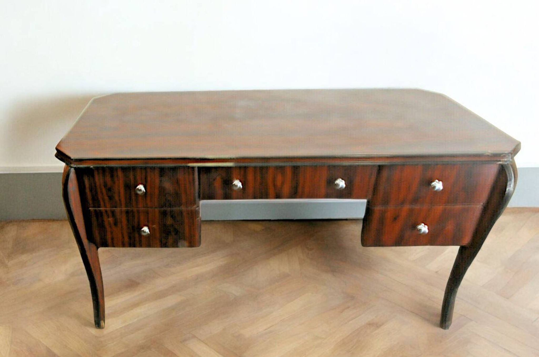 A large Art Deco style rosewood desk with 5 drawers and decorative motifs