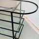 Mid-century console with glass top and metal frame.