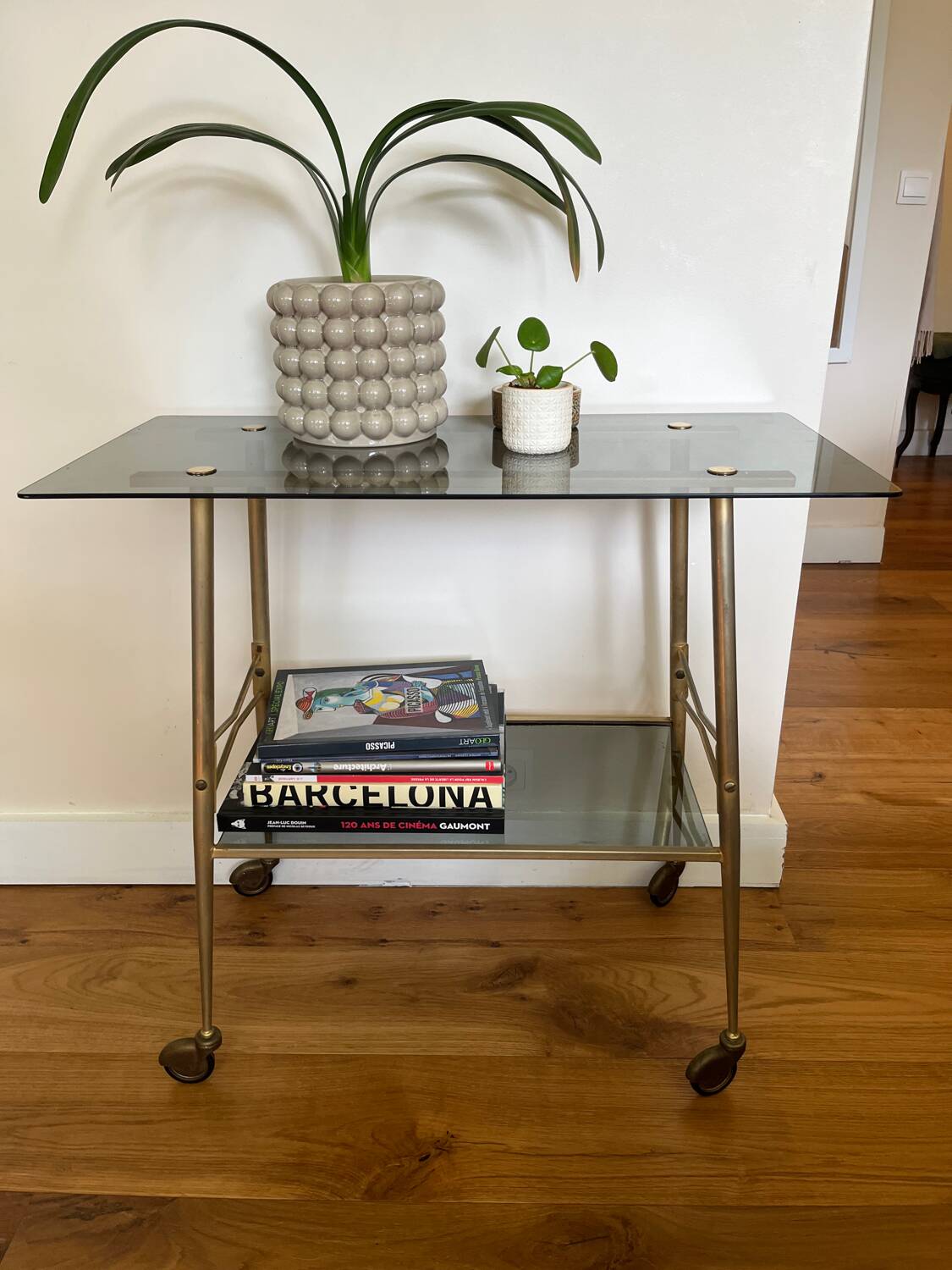 Vintage brass and smoked glass dessert trolley on wheels.