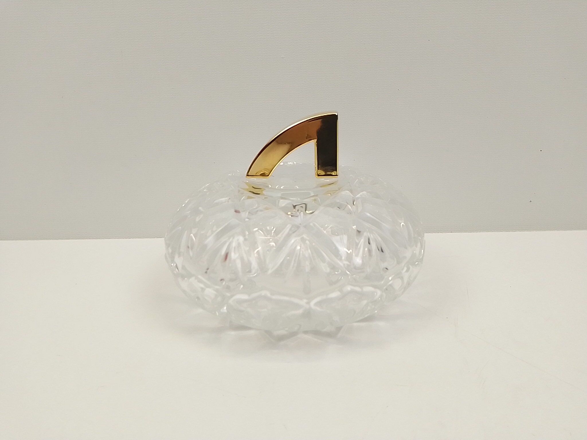 Round crystal box and a golden metal handle