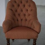 Victorian mahogany armchair, with wheels and coloured fabric, England, early 1900s.