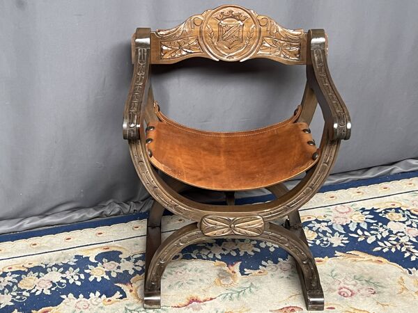 Fauteuil de style Dagobert. Noyer massif, cuir.