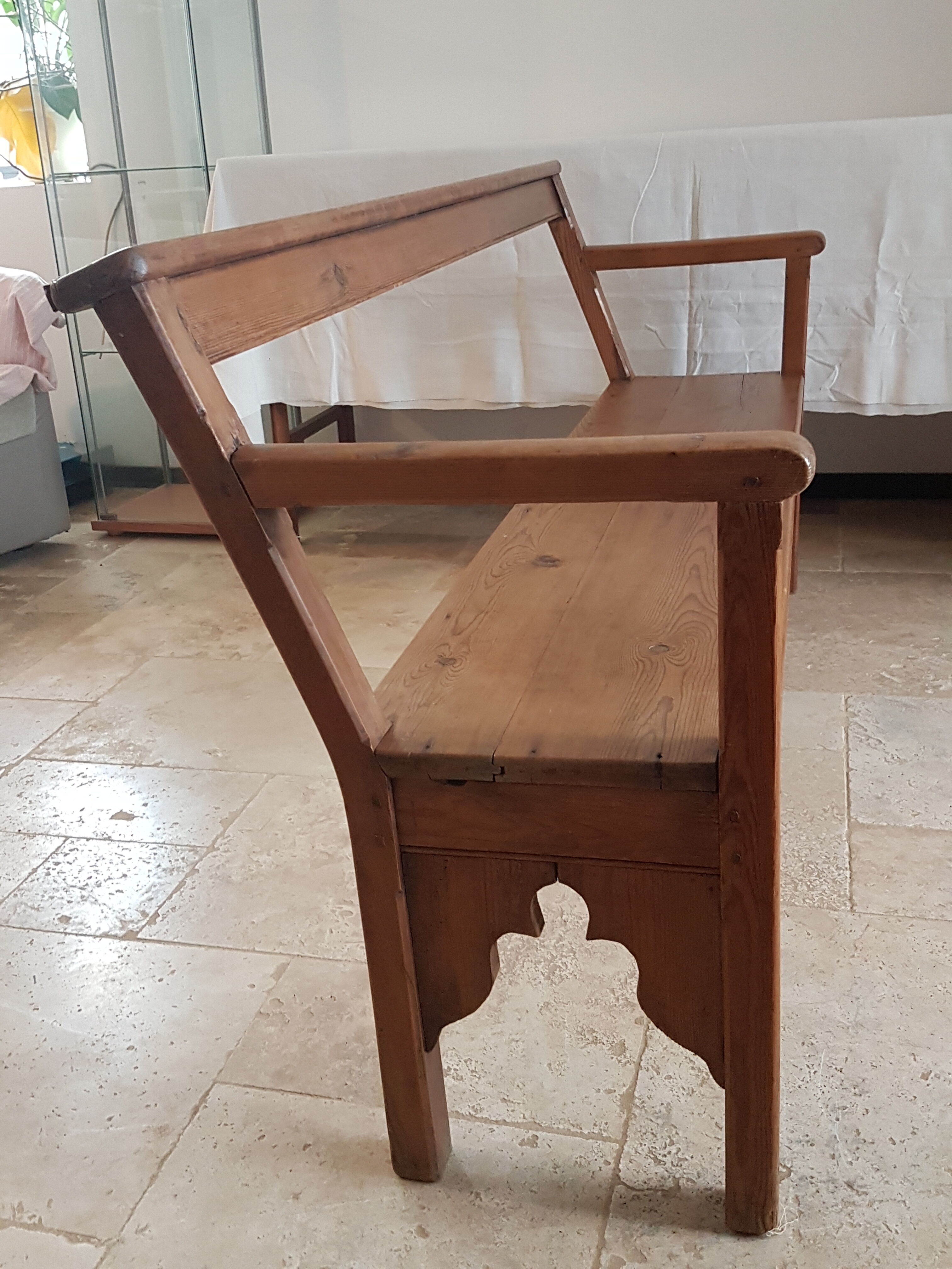 Church bench in fir tree with armrests