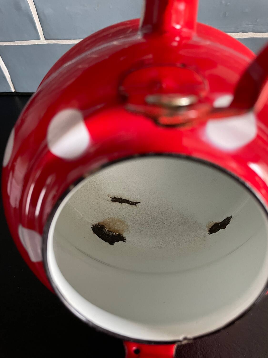 Red enameled sheet metal kettle with white polka dots