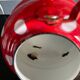 Red enameled sheet metal kettle with white polka dots
