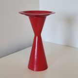 Vintage design candlestick in red metal in the shape of an hourglass