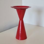 Vintage design candlestick in red metal in the shape of an hourglass