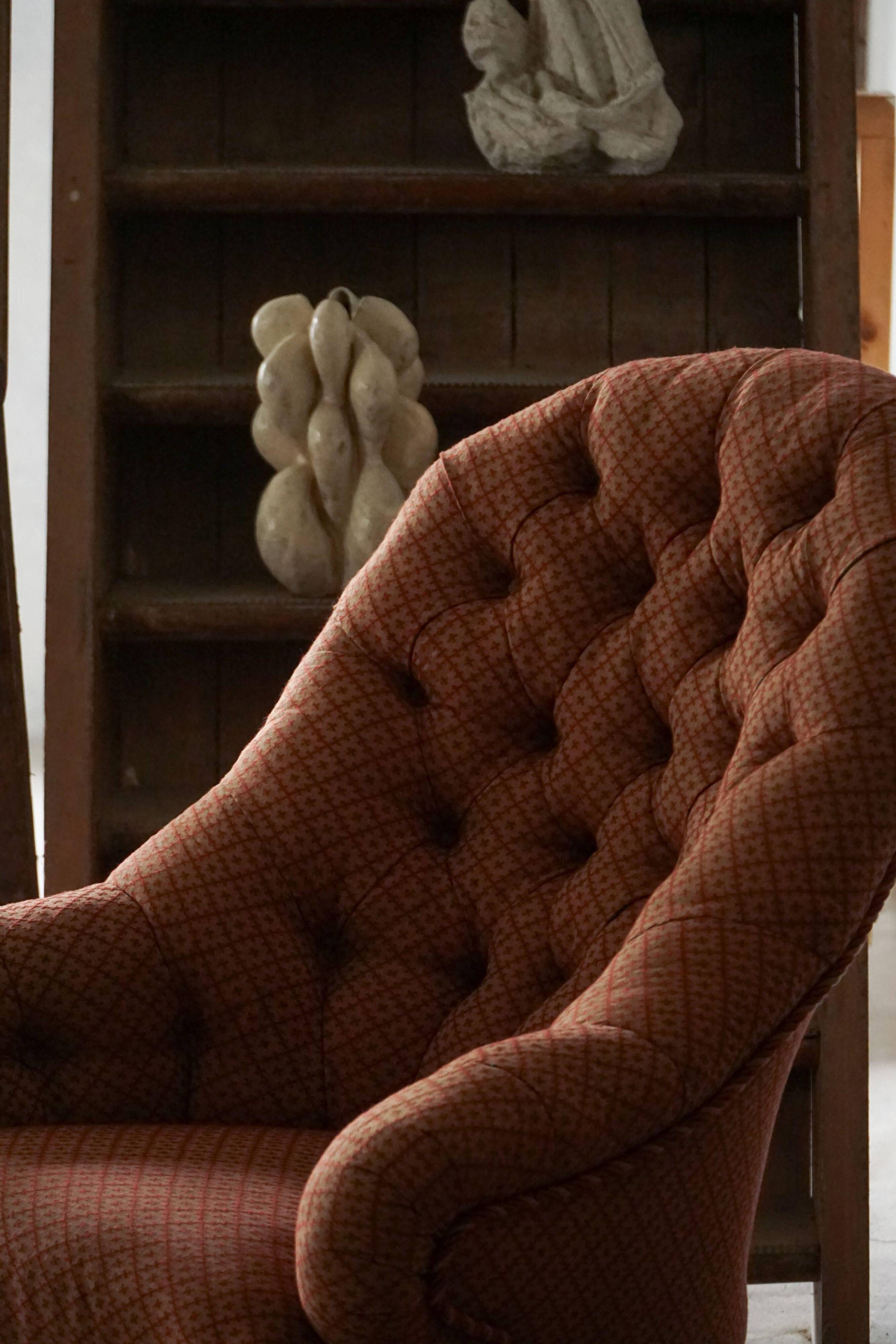 Victorian mahogany armchair, with wheels and coloured fabric, England, early 1900s.