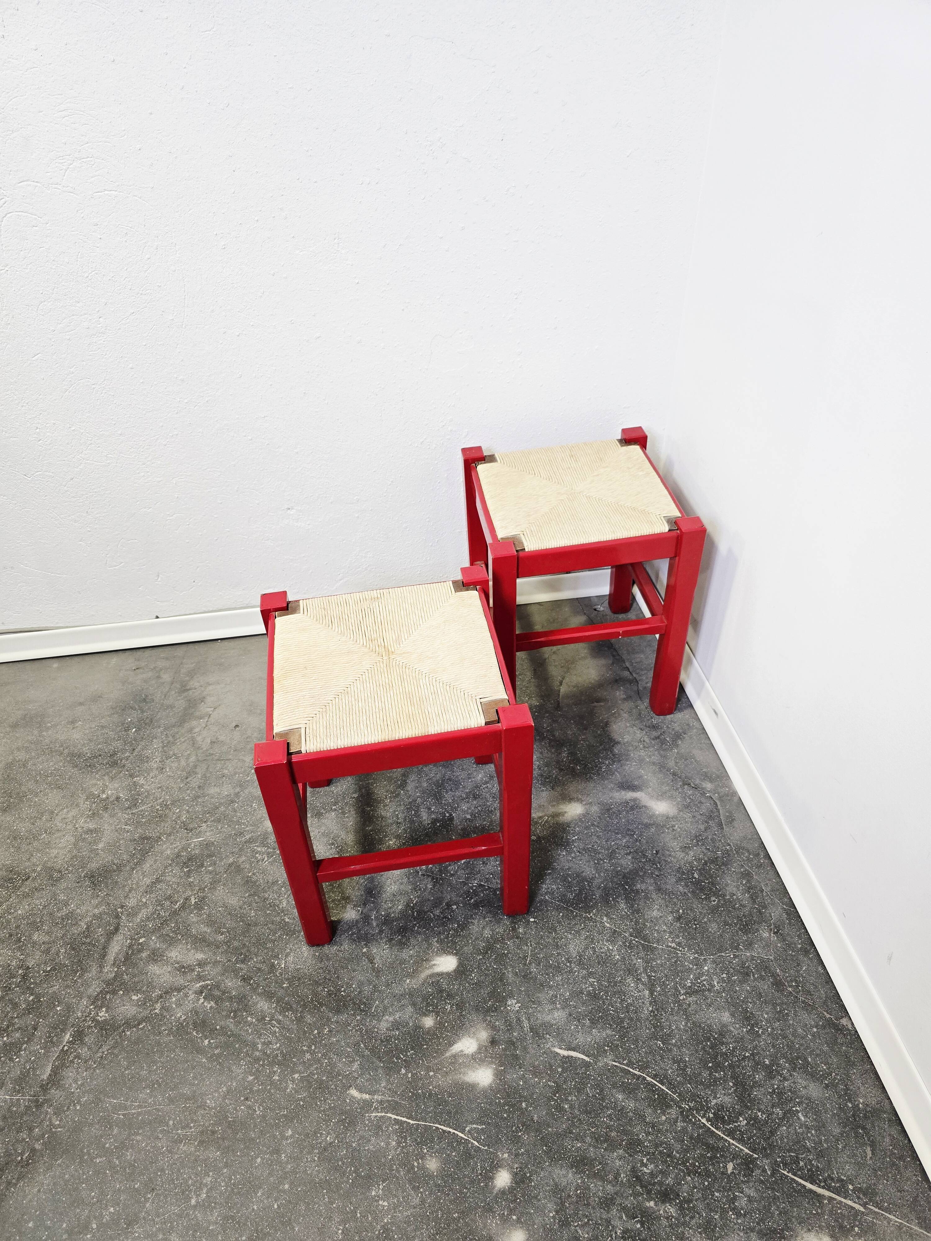 Red wooden stool with woven rush seat.