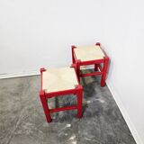 Red wooden stool with woven rush seat.