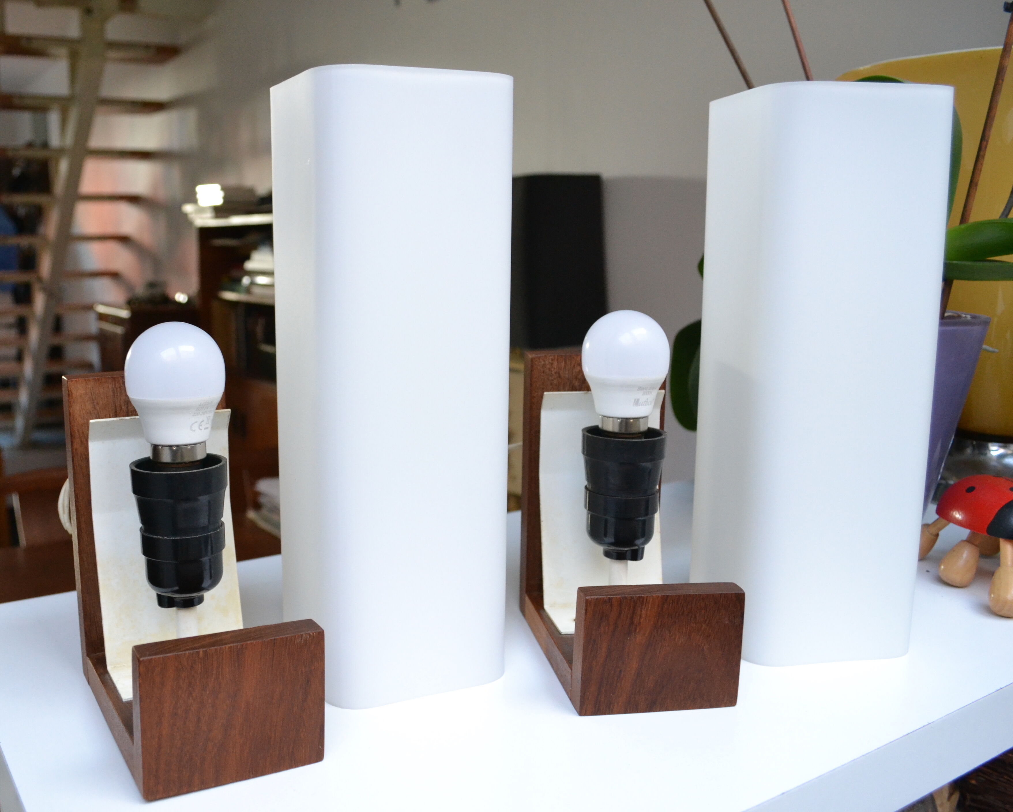 Pair of Louis Kalff opaline and teak wall lamps