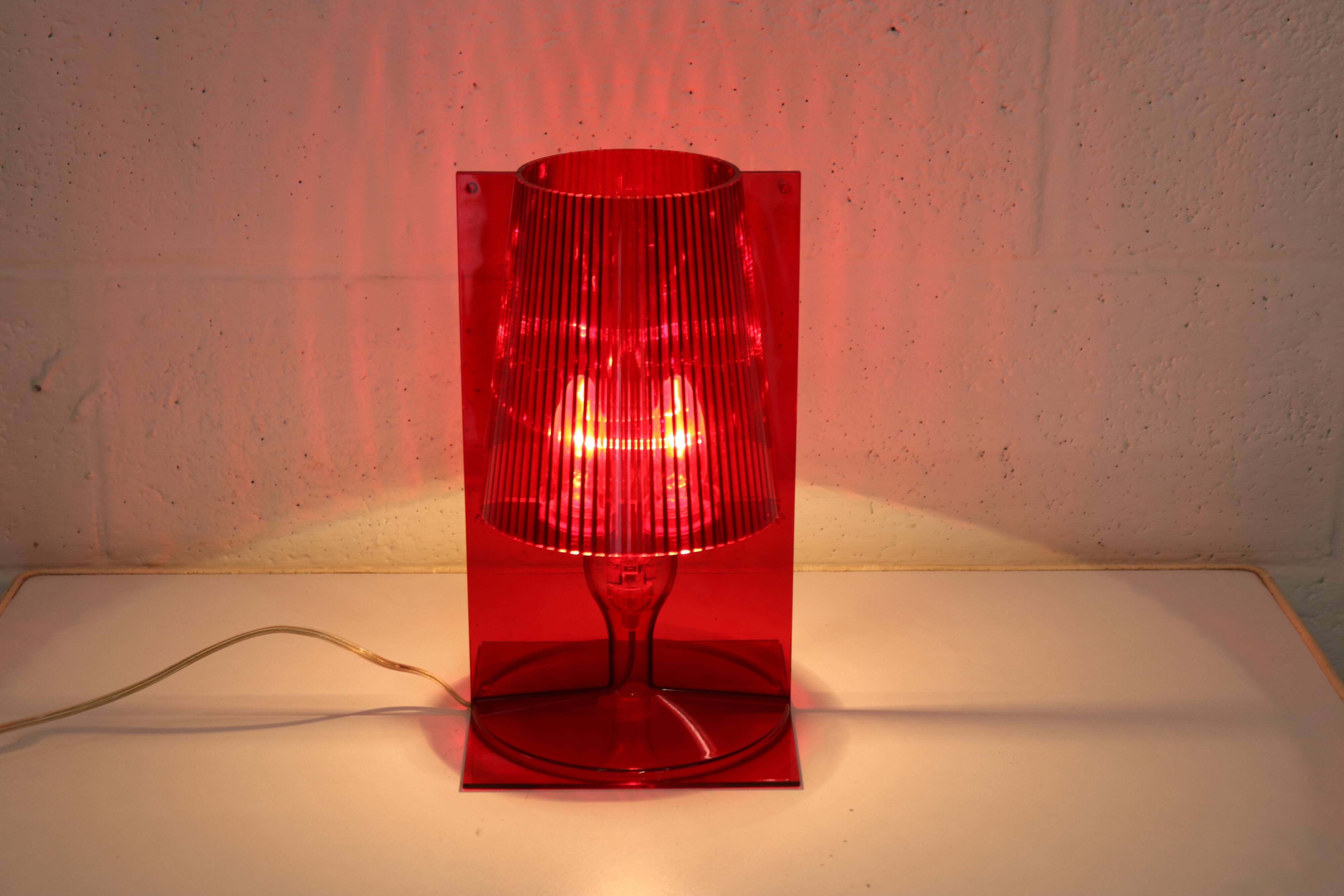 Red plastic Kartell table lamp - model Take - design by Ferruccio Laviani