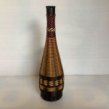 Old bottle in yellow, red and black scoubidou