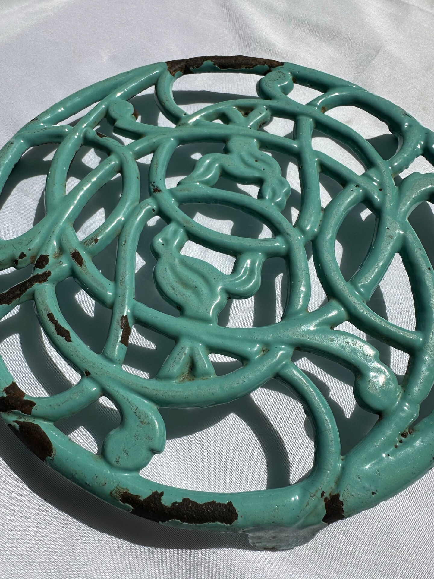 Enamelled cast iron trivet in blue with wrought iron decoration.
