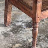 Small antique Indonesian bench in carved teak with plant and floral motifs.