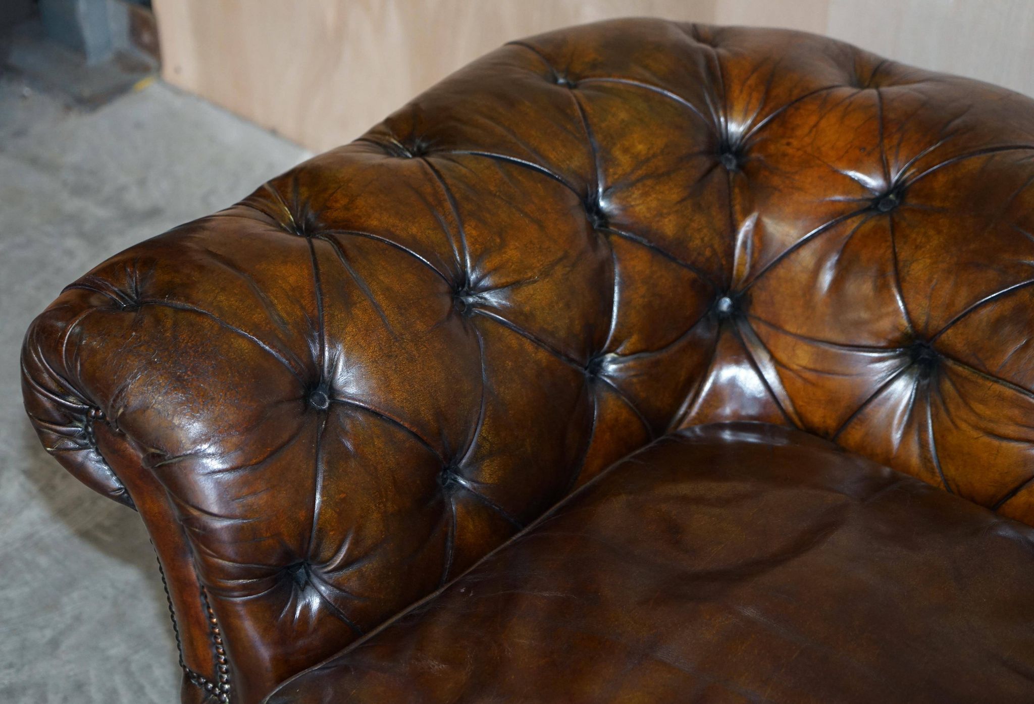 Victorian Chesterfield leather upholstered canapé with feather cushions.