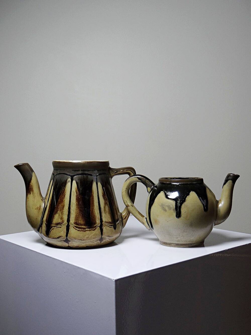 A pair of small vintage teapots in the Art Deco style reminiscent of Denbac.