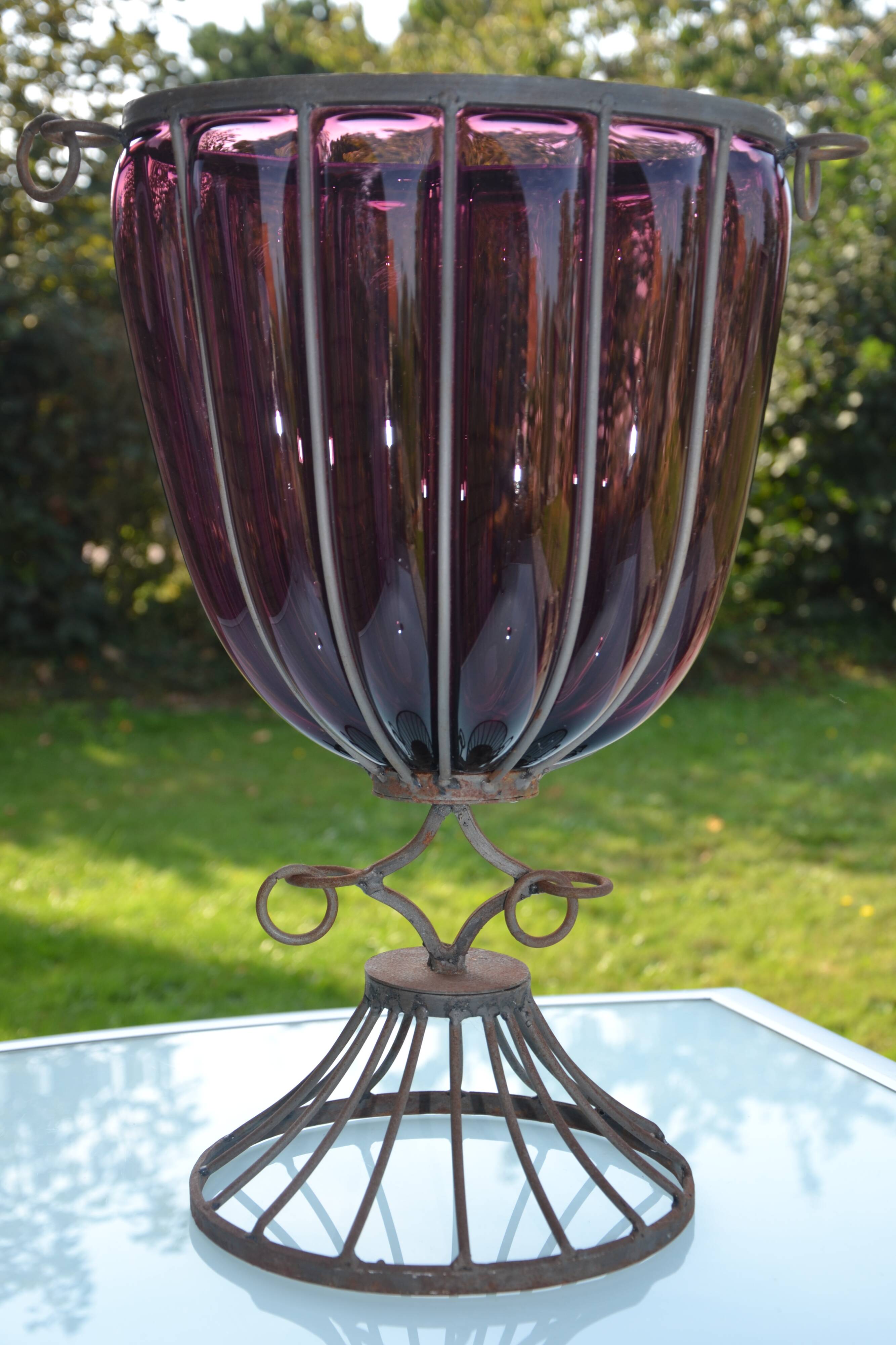 Large blown glass and wrought iron vase on shower stand