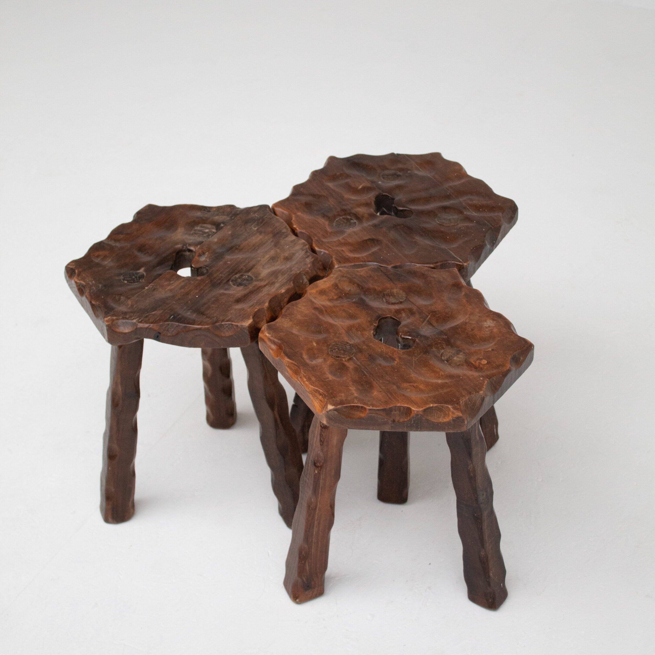 Ensemble de trois tabourets en bois sculptés à la main.