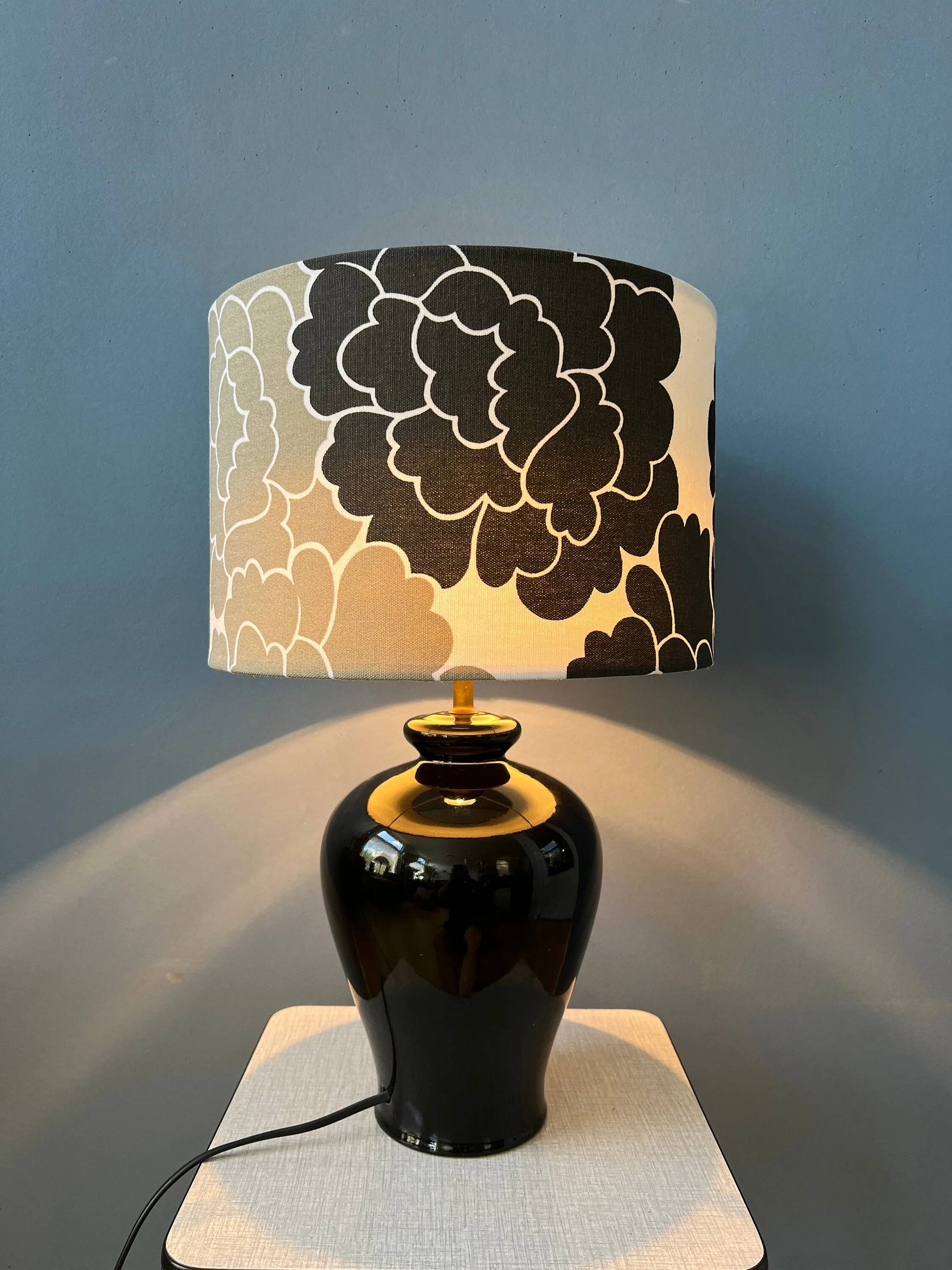 Small Space Age table lamp with a porcelain base and black and white flower shade.