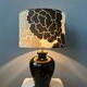 Small Space Age table lamp with a porcelain base and black and white flower shade.