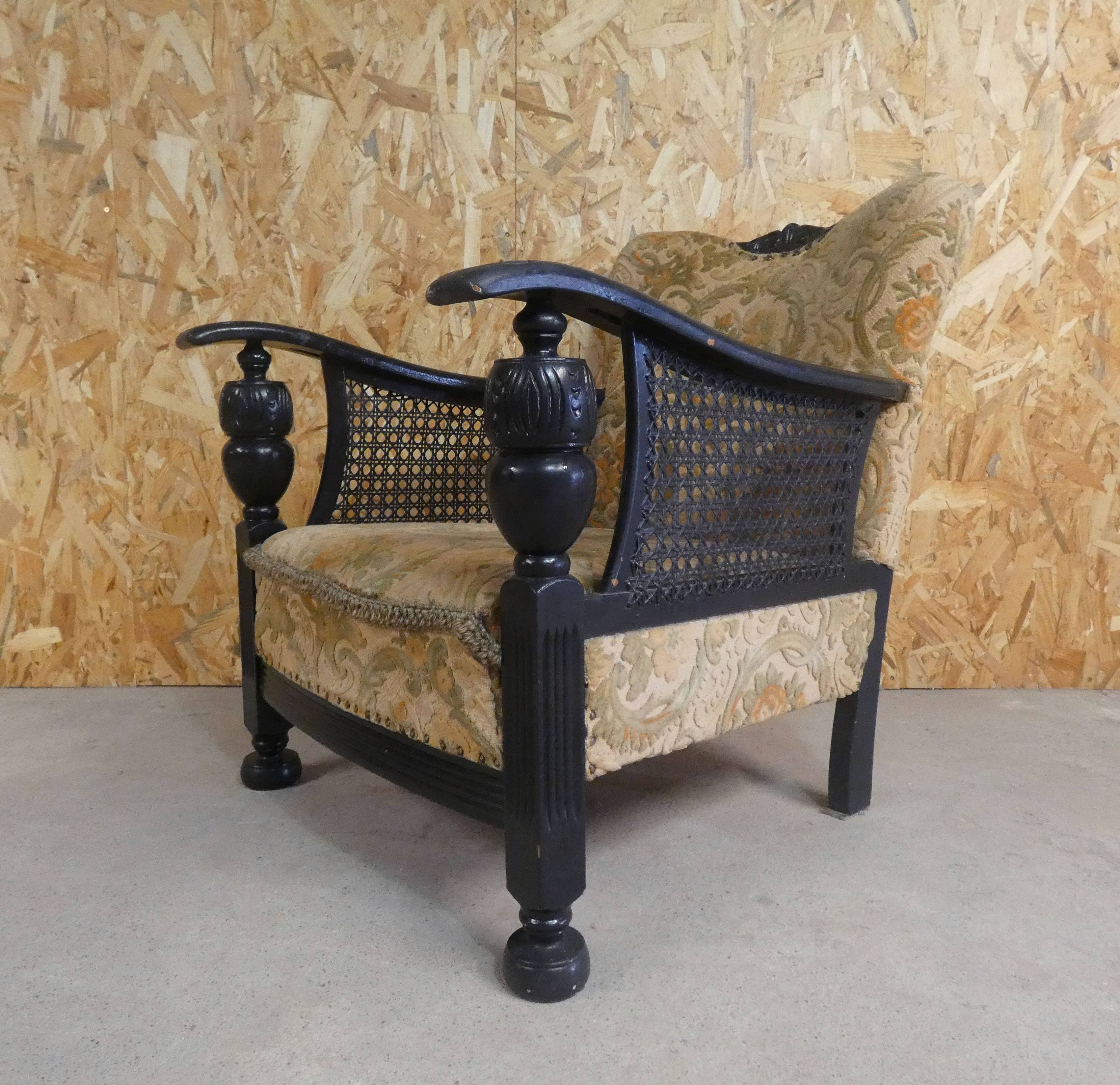 Old armchair upholstered in velvet, carved and caned wood