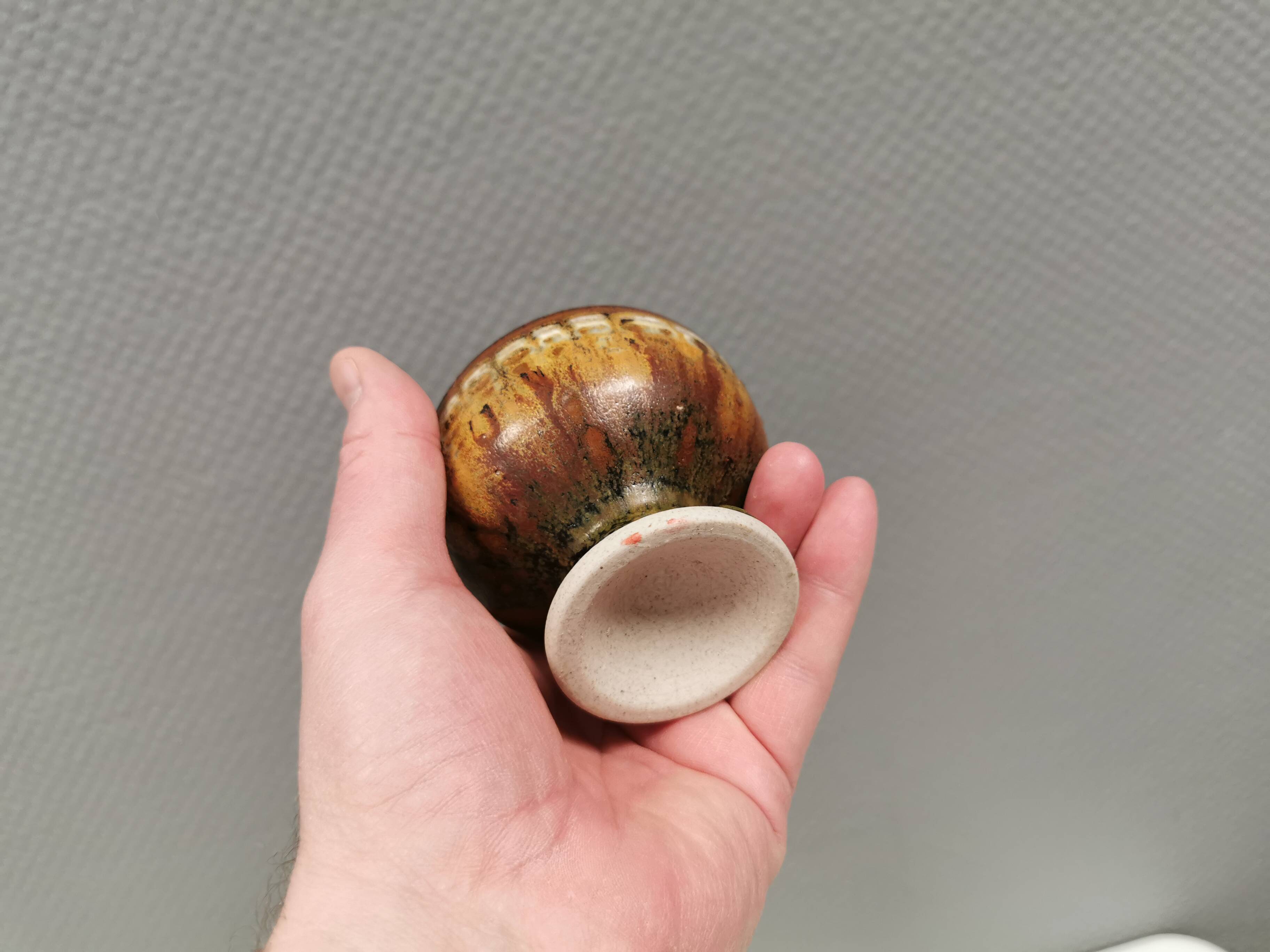 A set of ceramic candle holders in earthy colours.