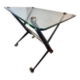 Table with thick glass top and black steel legs with casters