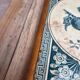 Antique trivet in Gien tile with blue bird decoration – wooden border