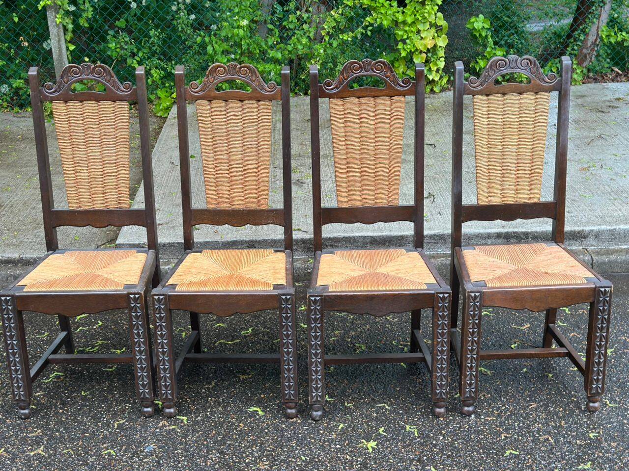 4 Basque solid wood dining chairs with carved straw seats.