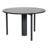 Round dining table in black lacquered metal with a granite top.