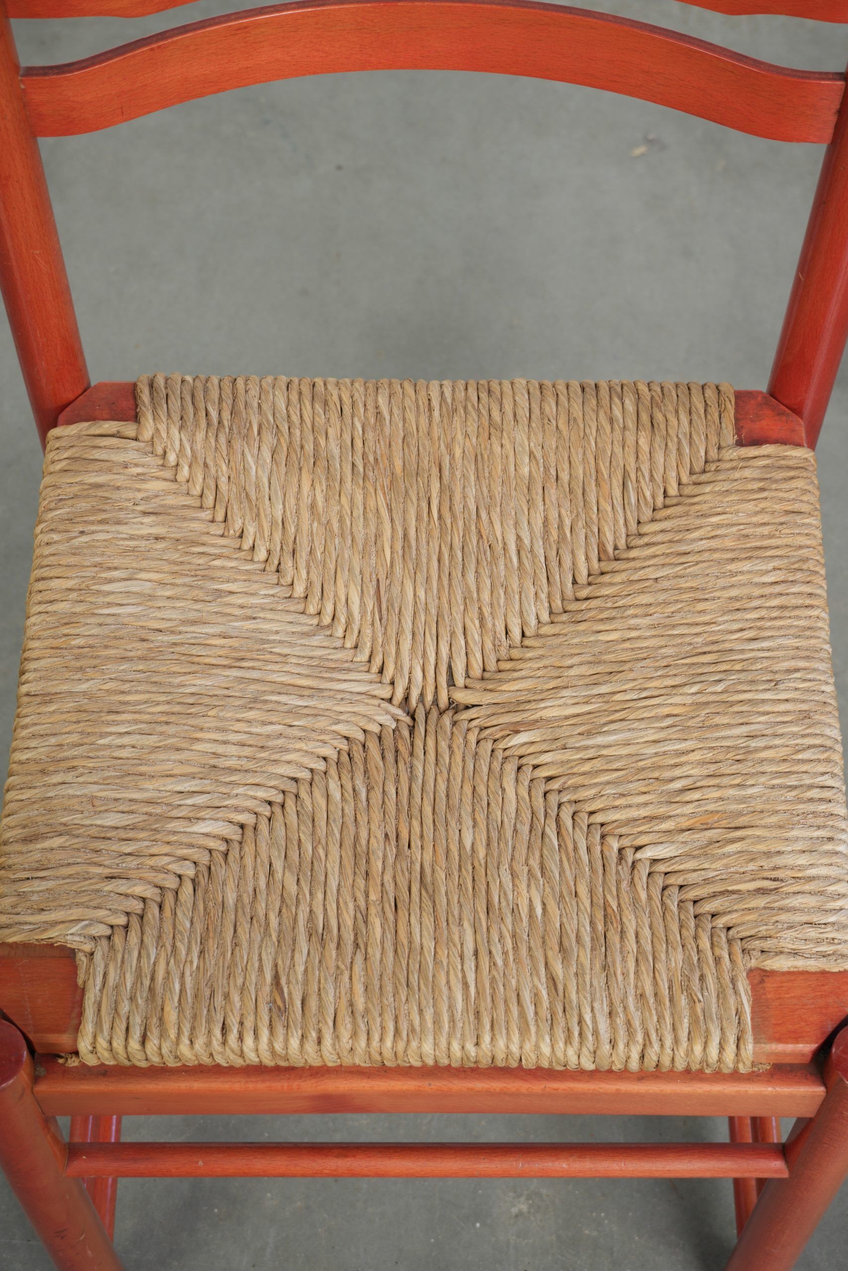 Nice red vintage wooden chair from the 1970s with a woven wicker seat