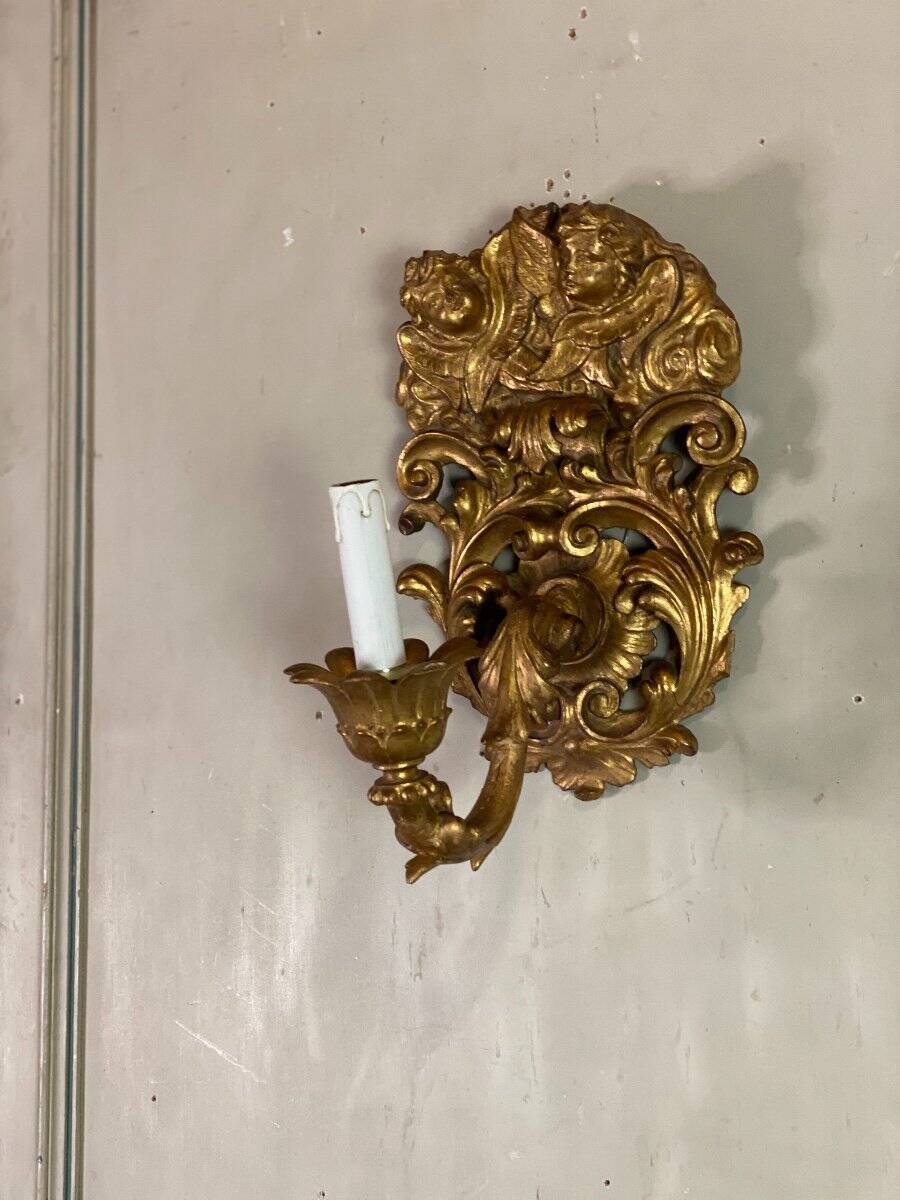 Paire d’appliques en bois sculpté et doré surmontées de deux têtes d’angelots, Italie