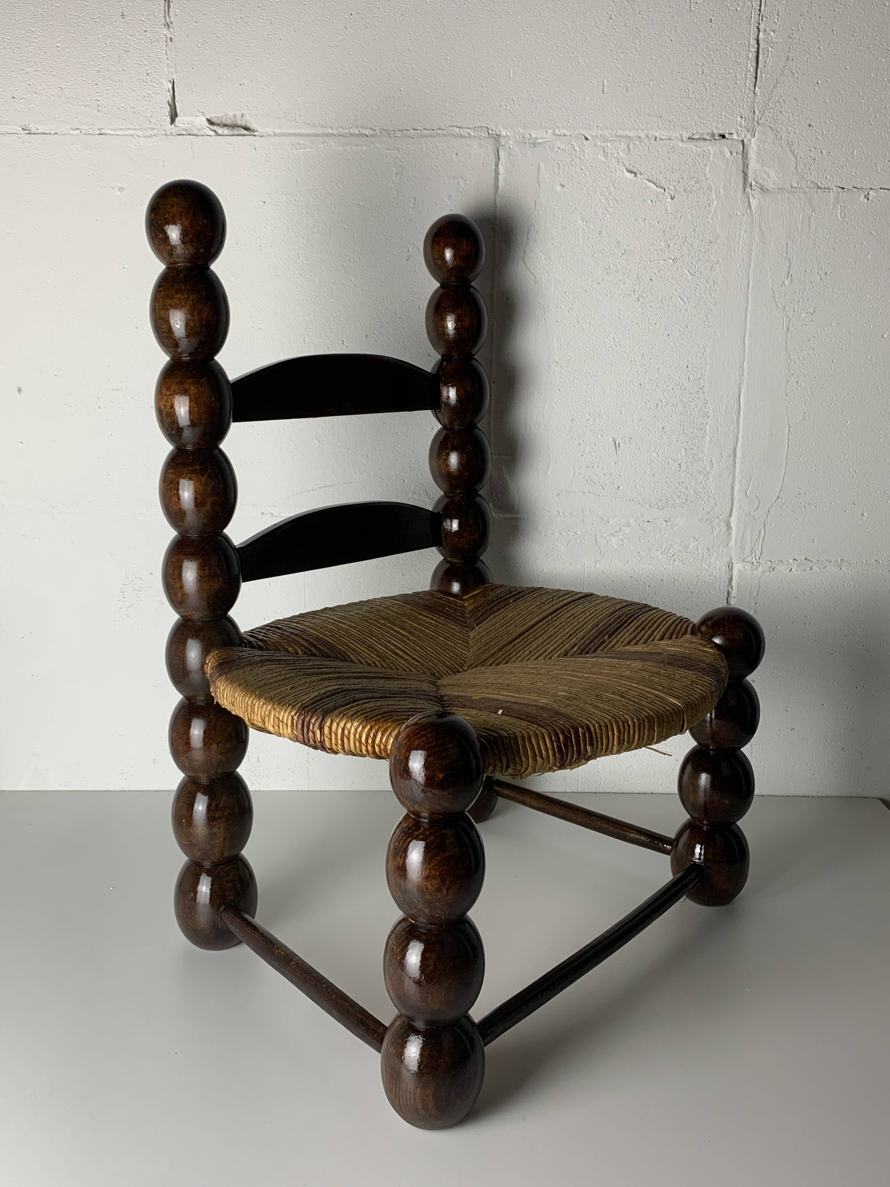 Brutalist wood turned bobbin low rush chair n the style of Charles Dudouyt