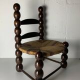 Brutalist wood turned bobbin low rush chair n the style of Charles Dudouyt