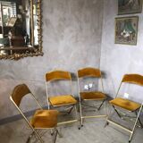 Four folding velvet and brass chairs