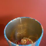 "Stoneware Bottle Lamp" with a multicoloured blue lampshade handwoven in India.