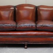 Restored Victorian sofa in leather with claw feet and feather cushions.