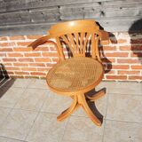 Vintage American swivel chair in wood and cane.