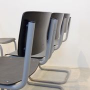 Ensemble de six chaises industrielles en contreplaqué Gispen dans un cadre gris et wengé.