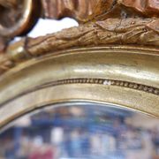 Wear consistent with age and use Wood and gilded plaster "Noeud d'Amour" Oval mirror