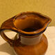 St. Clement brown ceramic pitcher, 1970