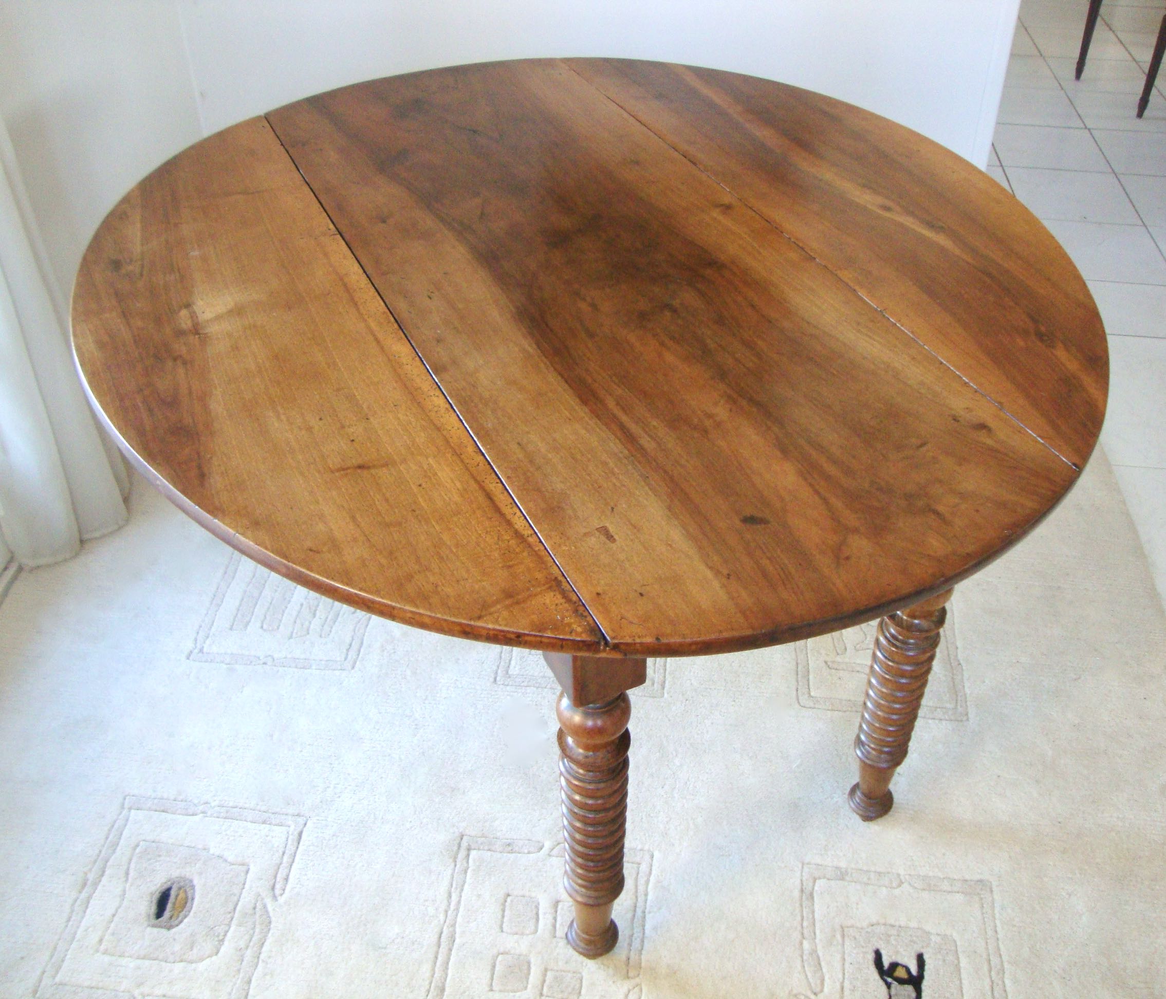 Mid-19th-century walnut round table with shutters, flaps
