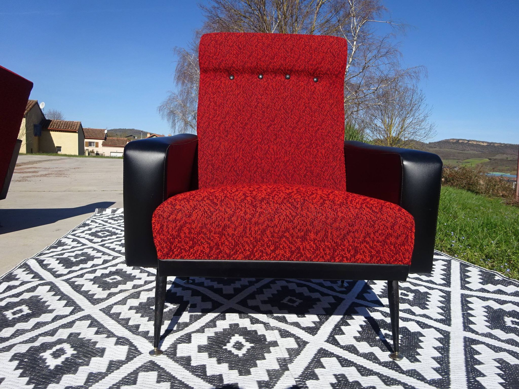 Pair of vintage armchairs in black faux leather and red fabric.