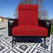 Pair of vintage armchairs in black faux leather and red fabric.