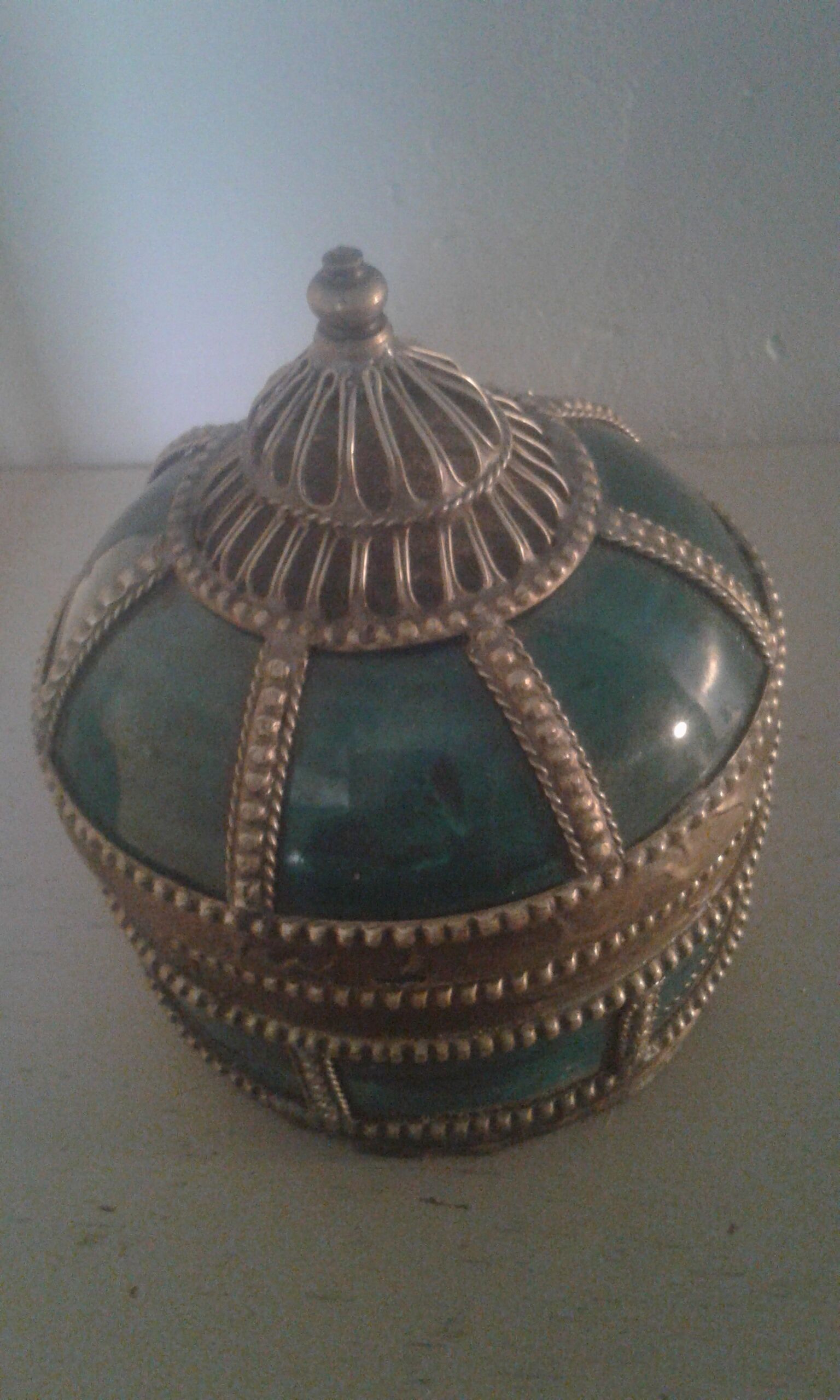 Ancient box in ceramic and enamel surrounded by brass