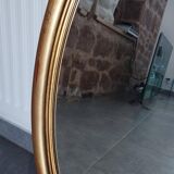 Large and elegant oval gilded mirror with its beveled glass