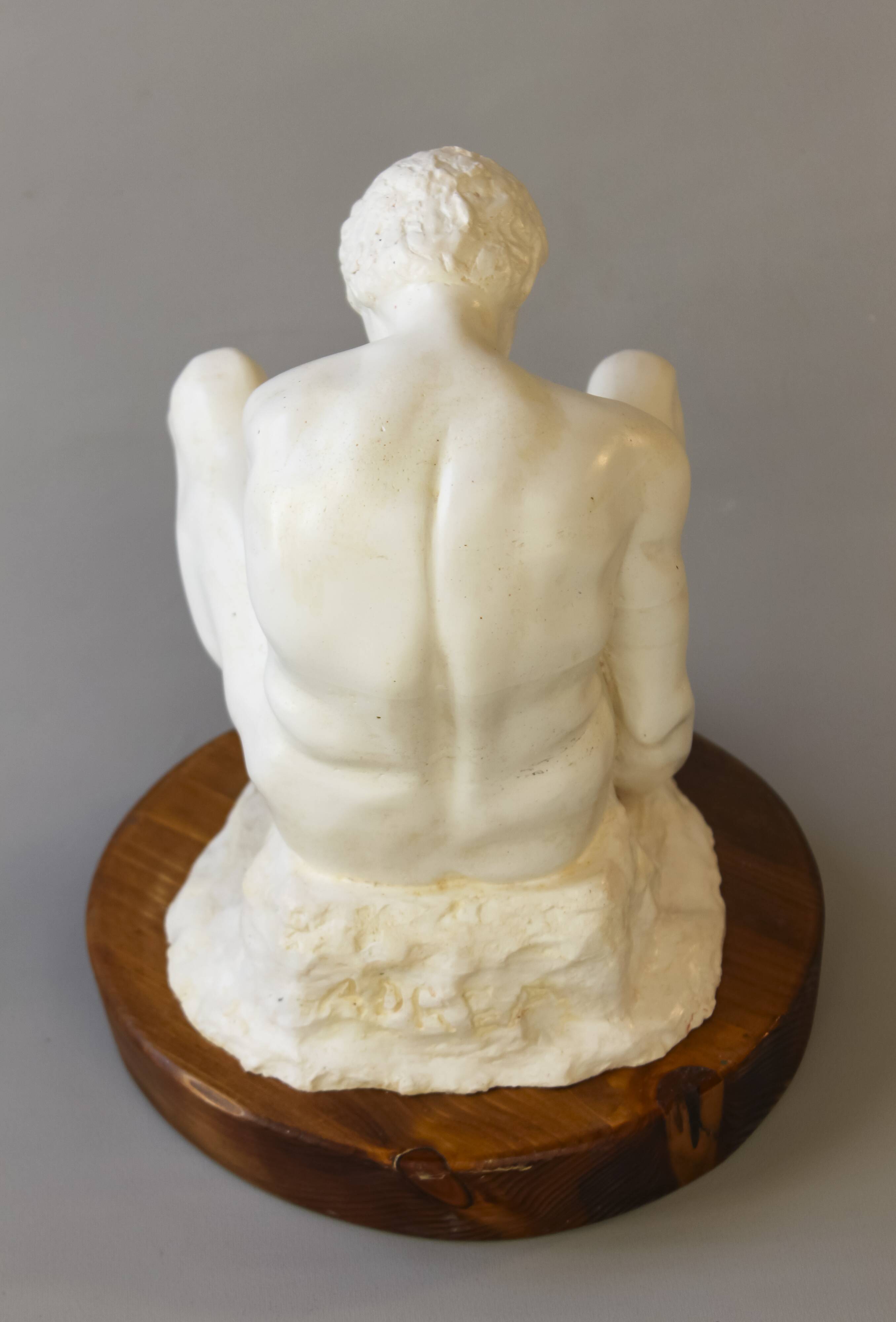 Sculpture of a seated man. Classical male sculpture. Male figure.